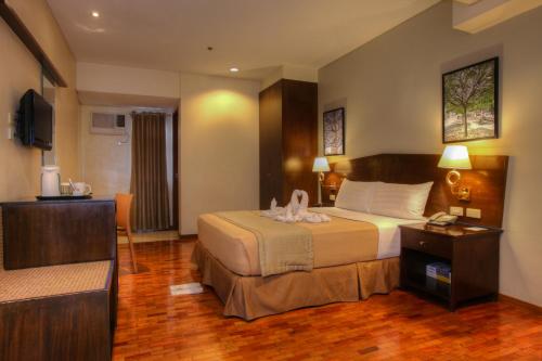 a hotel room with a bed and a television at Fersal Hotel Kalayaan, Quezon City in Manila