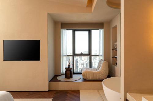 a bathroom with a large window and a television at Papman Hotel Kunming Xishan Wanda Branch in Kunming