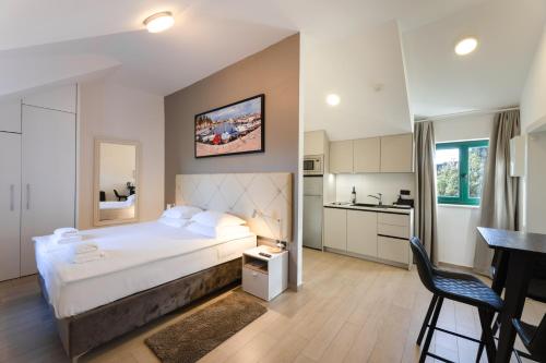 a bedroom with a large bed and a kitchen at Apartments Korta in Split