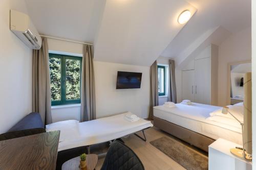 a hotel room with two beds and a window at Apartments Korta in Split