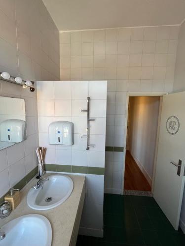 a bathroom with two sinks and a shower at Train Spot Guesthouse in Marvão