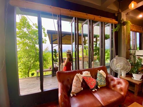 a woman standing on a screened in porch with a couch at บ้านผ่อดอยกอยดาวพรีเมี่ยม in Ban Sop Nong