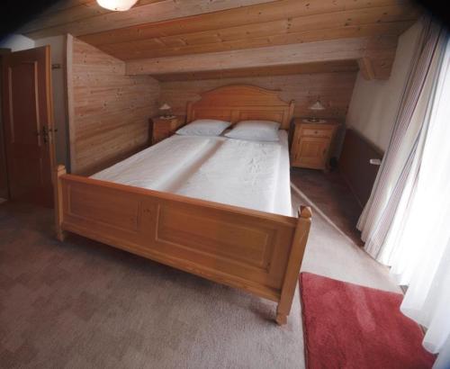 a bedroom with a wooden bed in a room at Neuhaus Apartments in Gosau