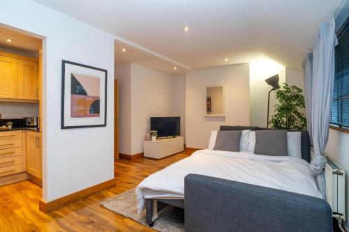 a bedroom with a large bed and a kitchen at Cuthbert Suite - Heart of Covent Garden! in London