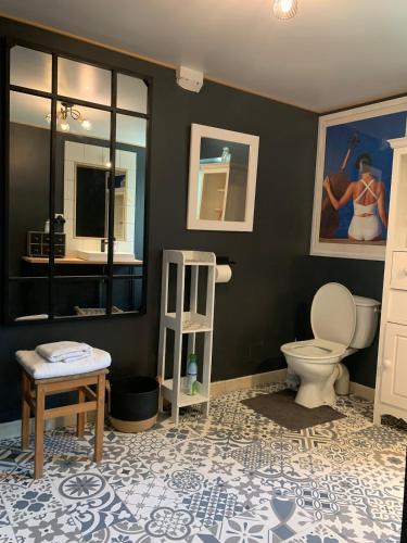 La salle de bains est pourvue de toilettes, d'une table et d'un miroir. dans l'établissement Charmante maison proche des châteaux de Loire, à Baule