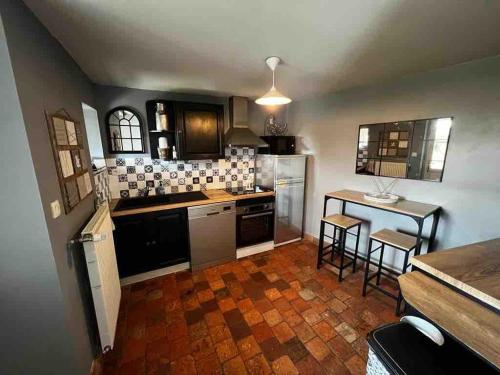 eine Küche mit Theke und Tisch mit Stühlen in der Unterkunft Charmante maison proche des châteaux de Loire in Baule