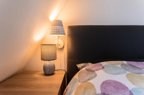 a lamp sitting on a table next to a bed at Le 16 - Parking city center in Colmar