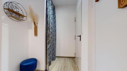 un couloir avec une chaise bleue et une cravate sur un mur dans l'établissement expat renting - Le Chic - Netflix - Proche gare, à Toulouse