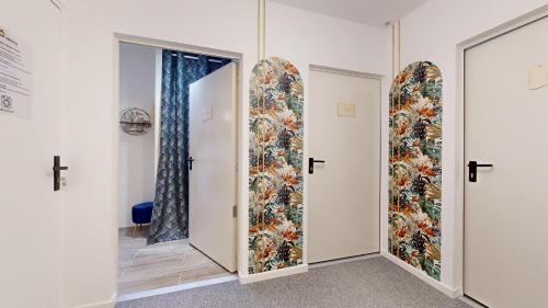 un couloir avec trois portes et un tableau mural dans l'établissement expat renting - Le Chic - Netflix - Proche gare, à Toulouse