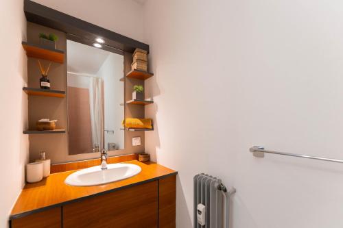 a bathroom with a sink and a mirror at Le 16 - Parking city center in Colmar