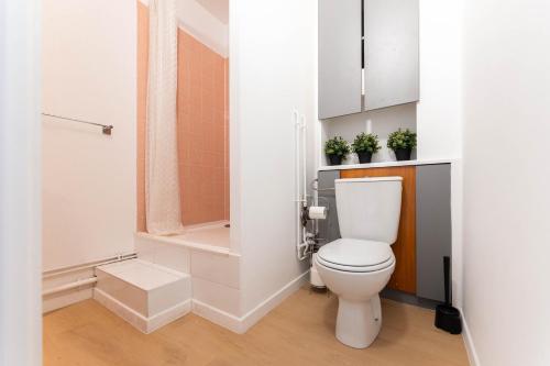 a white bathroom with a toilet and a shower at Le 16 - Parking city center in Colmar
