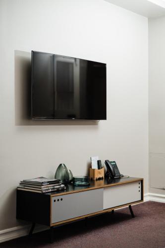 a flat screen tv on a wall above a coffee table at Reykjavik Residence Apartment Hotel in Reykjavík