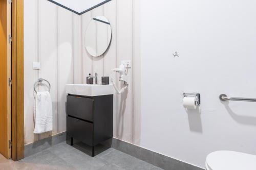 a bathroom with a sink and a mirror at Posada de los Venerables in Seville