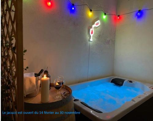 une baignoire jacuzzi avec bougie et quelques lumières dans l'établissement Suite Grand Cru - SPA & terrasse, à Arveyres