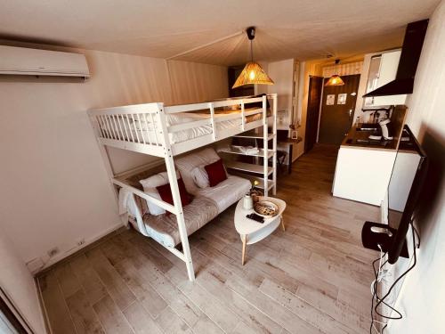 une chambre avec deux lits superposés et un canapé dans l'établissement Rivage de March Land - Parking Gratuit, à La Grande Motte