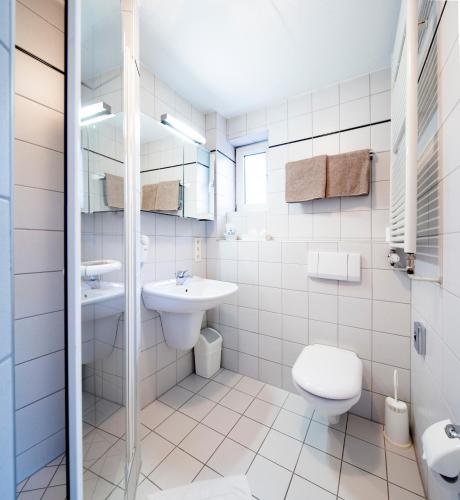 a white bathroom with a toilet and a sink at Nürnberger Trichter Family-Business Hotel Garni in Nürnberg