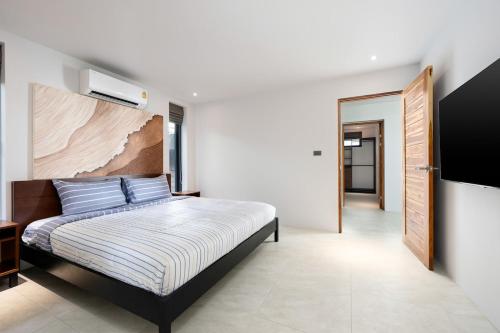 Un dormitorio con una cama y un televisor de pantalla plana. en Penthouse 2BR Seaview Top Floor, en Ban Thong Phlu