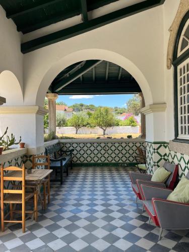 an outdoor patio with chairs and tables and an archway at Train Spot Guesthouse in Marvão