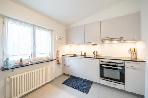 a white kitchen with white cabinets and a window at Swissholiday in Woschnau