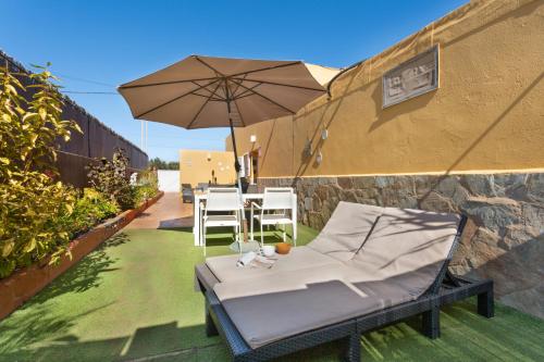 a patio with an umbrella and a table and chairs at Apt Rural Zona Céntrica Isla in Puerto del Rosario