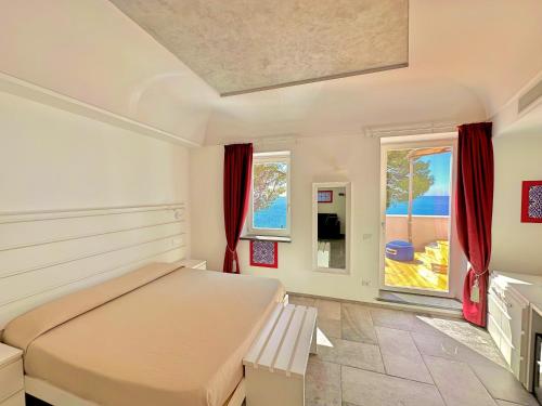 a bedroom with a large bed and two windows at Villa Bossa Amalfi in Amalfi