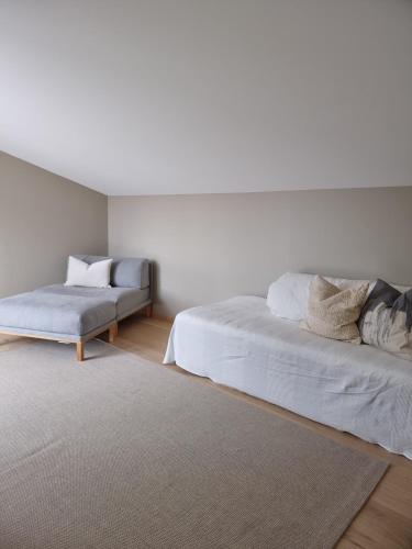 a white room with two beds and a rug at Seaside Holiday Home in Hjelmeland