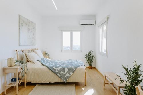 Un dormitorio blanco con una cama y dos ventanas. en Stylish Stonehouse in Platres, en Platres