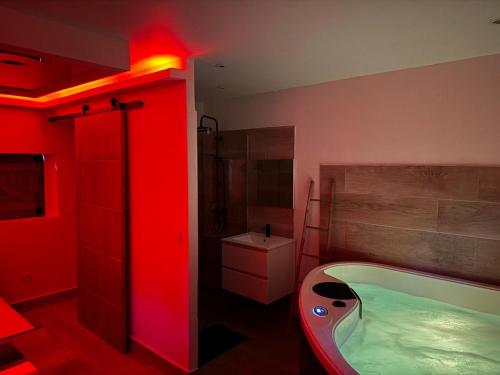 a bathroom with a tub and a red light at Love Room Ô Fruit de la passion in Le Gosier