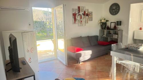 un salon avec un canapé et une télévision dans l'établissement La maison aux volets bleus, à Draguignan