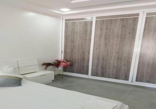 a bedroom with a bed and wooden sliding doors at Keur Dior Diagne in Thiès