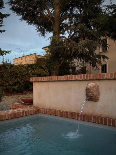 a swimming pool with a fountain in a yard at The House in Strevi