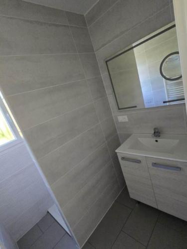 une salle de bain blanche avec un lavabo et un miroir dans l'établissement Maison Monsegur, à Monségur