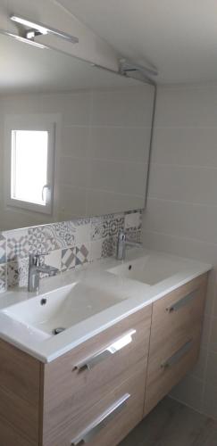 La salle de bains est pourvue d'un grand lavabo blanc et d'un miroir. dans l'établissement Maison Le Fenouiller Vendée 8 personnes 3 étoiles, à Le Fenouiller