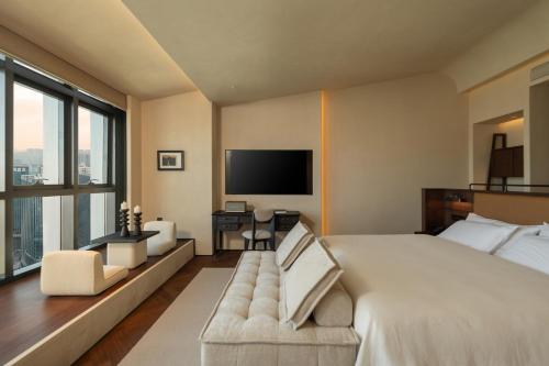a bedroom with a large bed and a television at Papman Hotel Kunming Xishan Wanda Branch in Kunming