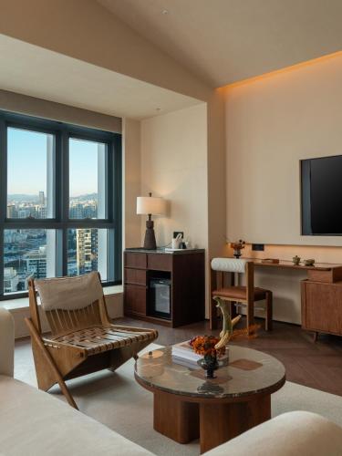a living room with a couch and a table and a television at Papman Hotel Kunming Xishan Wanda Branch in Kunming