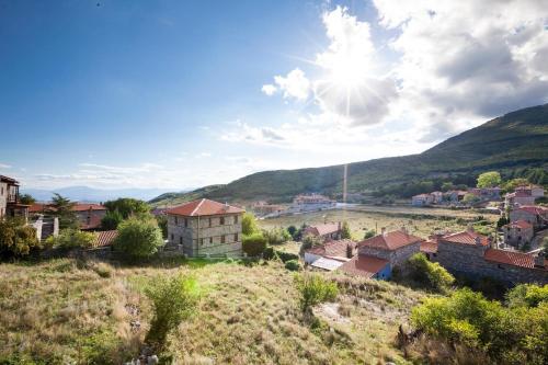 a village in the mountains with the sun in the sky at Dandy Villas Palios Agios Athanasios - Attic - Fireplace - Village Square in Palaios Agios Athanasios