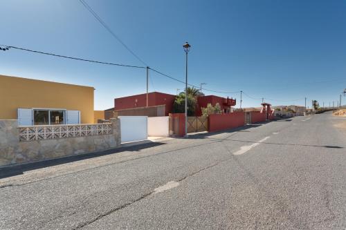 an empty street with a fence and a building at Apt Rural Zona Céntrica Isla in Puerto del Rosario