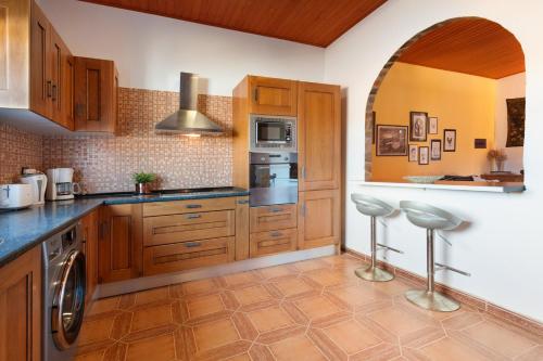 a kitchen with wooden cabinets and stainless steel appliances at Apt Rural Zona Céntrica Isla in Puerto del Rosario