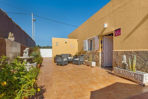 a patio outside of a house with chairs and a building at Apt Rural Zona Céntrica Isla in Puerto del Rosario