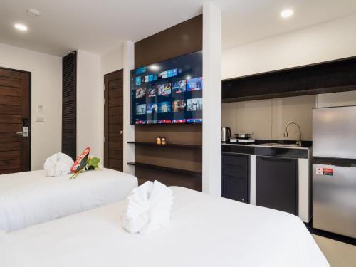 two beds in a room with a kitchen at Samutprakarn Hotel in Samut Prakan