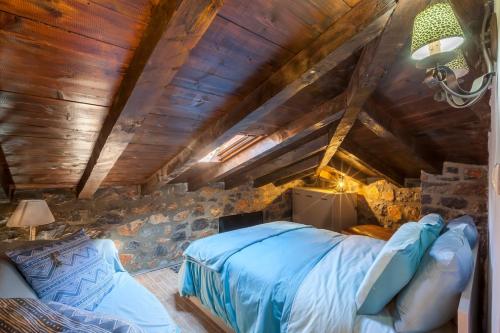 a bedroom with a bed and a stone wall at Dandy Villas Palios Agios Athanasios - Attic - Fireplace - Village Square in Palaios Agios Athanasios