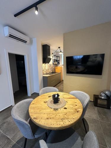 a wooden table and chairs in a living room at Apartments Urban in Poreč
