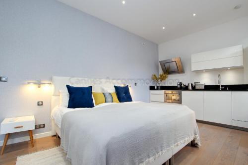 une chambre avec un grand lit blanc avec des oreillers bleus dans l'établissement Pampelonne, à Cannes