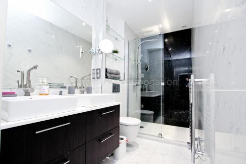 une salle de bain blanche avec un lavabo et une douche dans l'établissement Pampelonne, à Cannes