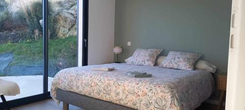 une chambre avec un lit et une grande fenêtre dans l'établissement Maison récente plain-pied Crozon proche plage commerces, à Crozon