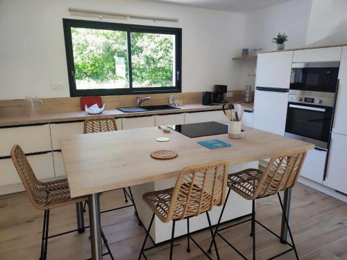 une cuisine avec une grande table et des chaises en bois dans l'établissement Maison récente plain-pied Crozon proche plage commerces, à Crozon
