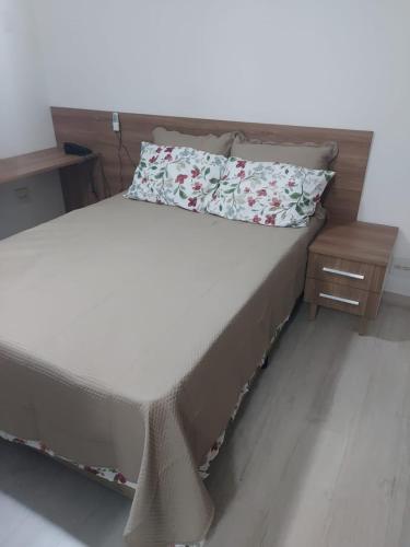 a bed in a room with avertisementatronatronstrationstrationstrationstrationstrationstration at Flat próximo ao Shopping e Praia in São Vicente