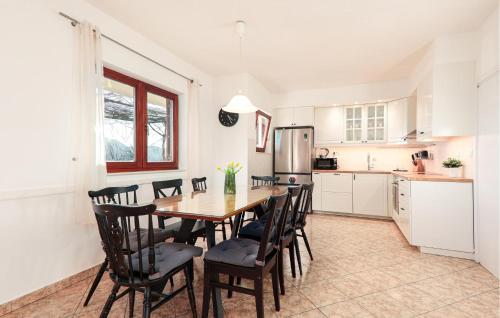 a kitchen and dining room with a wooden table and chairs at Five-Bedroom Holiday Home In Blato Na Cetini in Blato na Cetini