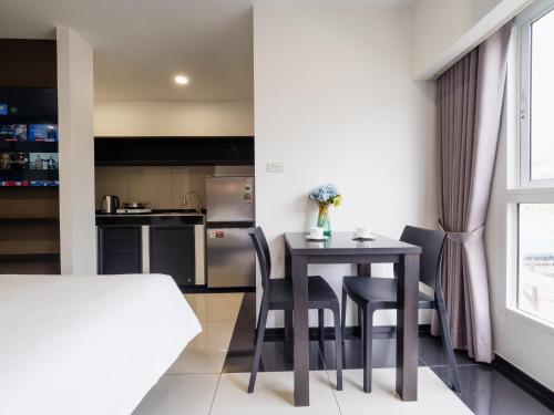 a kitchen and dining room with a table and chairs at Samutprakarn Hotel in Samut Prakan