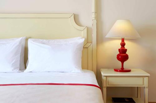a bedroom with a bed with a red lamp on a night stand at Alkyon Resort Hotel & Spa in Vrahati